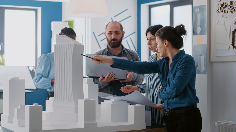 multi-ethnic-people-working-with-laptop-tablet-building-model-architecture-project-coworkers-doing-teamwork-design-maquette-construction-layout-with-blueprints_482257-38871.jpg